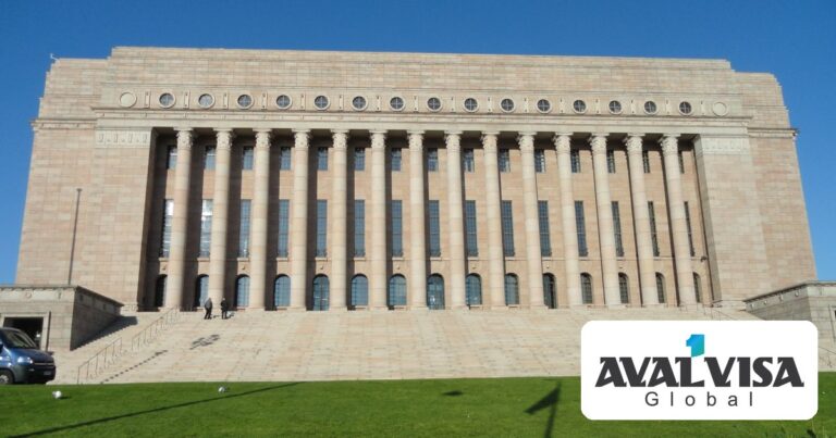 The Parliament House of Finland in Helsinki, with its granite columns and wide front steps under a clear blue sky